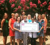 A group of people holding up a large check.