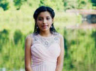 A girl in a pink dress posing for the camera.